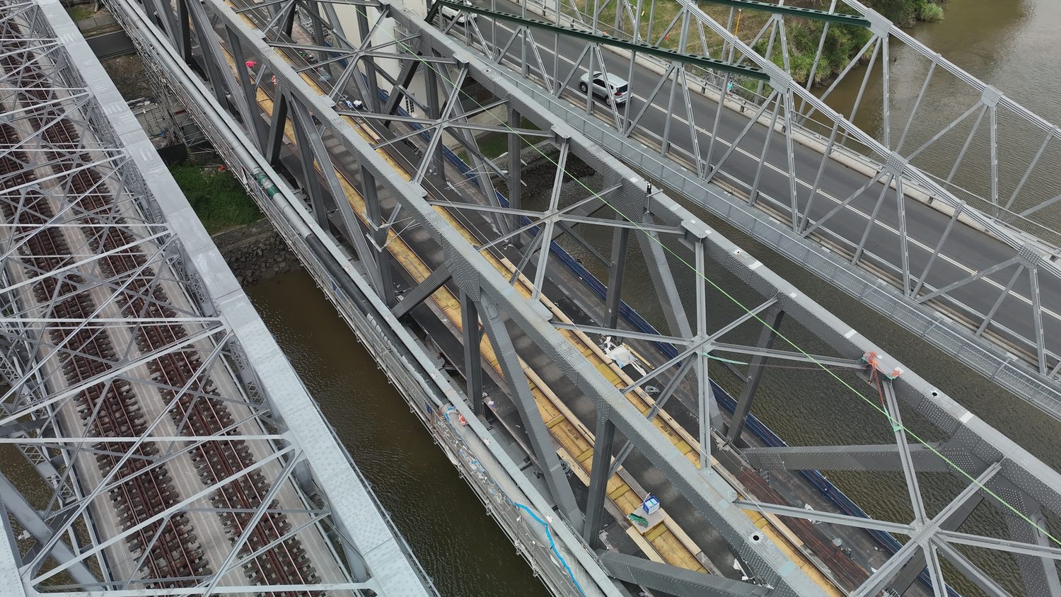 Wide drone view along the Indooroopilly rail bridge trusses during close visual inspection