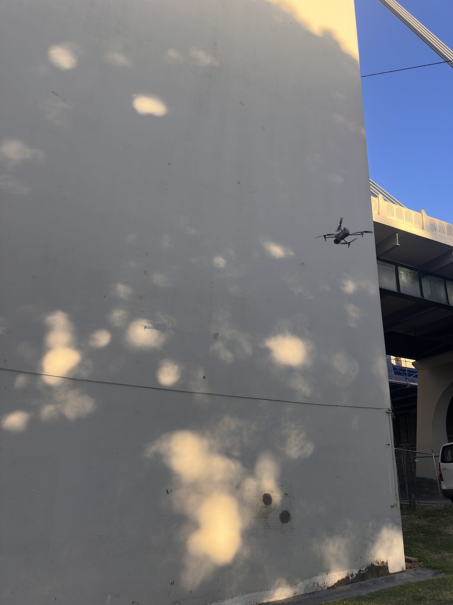 CASA-certified inspection drone holding position beside a Brisbane bridge tower over the river